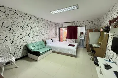 a small bedroom with a bed and a chair at Green Place 107 in Bangkok