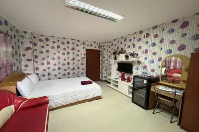 a bedroom with a bed and a desk in a room at Green Place 107 in Bangkok