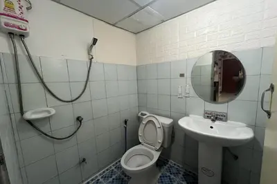 a bathroom with a toilet and a sink and a mirror at Green Place 107 in Bangkok