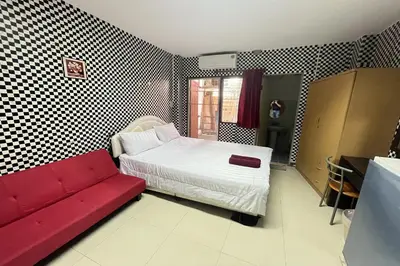 a bedroom with a bed and a red couch at Green Place 107 in Bangkok