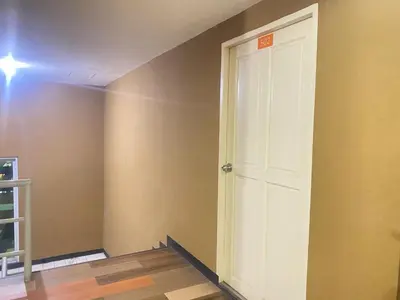 an empty room with a white door and a wall at Cream house in Salaya
