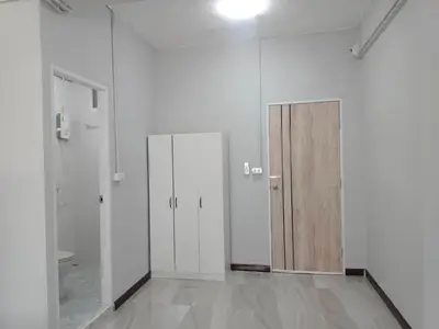 a room with three doors in a white room at The Little home in Ban Khlong Mae Nam Bon