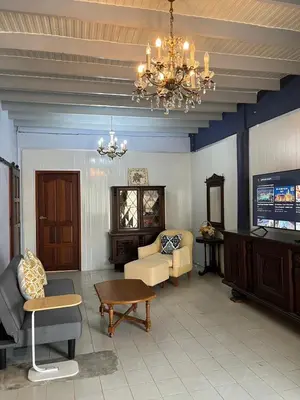 a living room with a couch and a chandelier at Baan Saen Saran residence in Sathani Bang Ramat