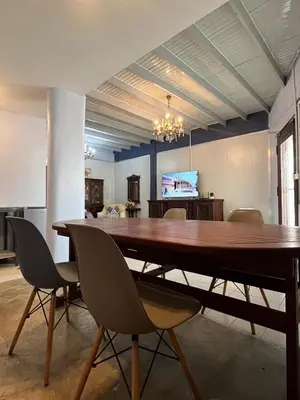 a dining room with a large wooden table and chairs at Baan Saen Saran residence in Sathani Bang Ramat
