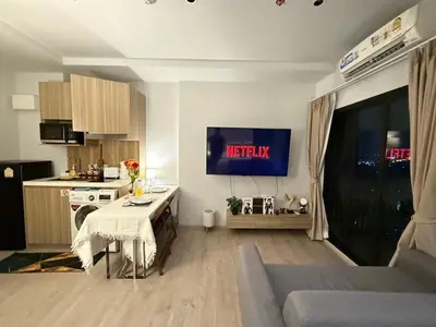 a living room with a table and a kitchen with a tv at 1 bedroom condo, next to BTS Talat Phlu, 0 meters, near Iconsiam, monthly room available in Bangkok