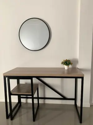 a table with a mirror and a bench with a plant at Ari45 in Bangkok
