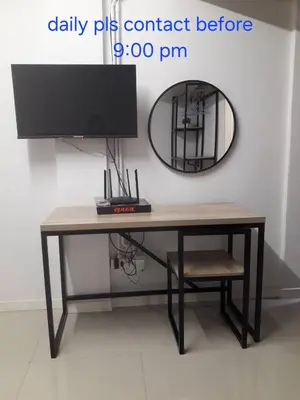 a desk with a tv and a mirror on a wall at Ari45 in Bangkok