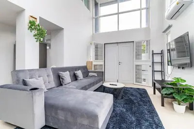 a living room with a couch and a table at Modern Townhouse City Center 4 Floors 13 Guests in Bangkok