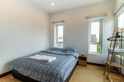 a bedroom with a bed and two windows at Modern Townhouse City Center 4 Floors 13 Guests in Bangkok