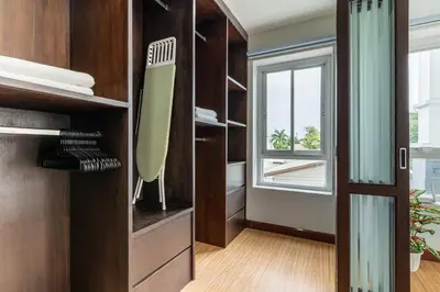 a kitchen with wooden cabinets and a large window at Modern Townhouse City Center 4 Floors 13 Guests in Bangkok