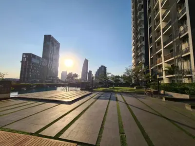 a park in a city with the sun setting behind buildings at Comfort Zone in Bangkok