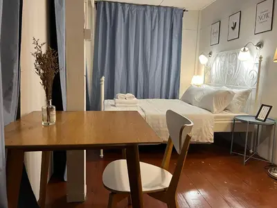 a bedroom with a bed and a table and a table and chairs at 3 bedrooms 2 bathroom's in Bang Su