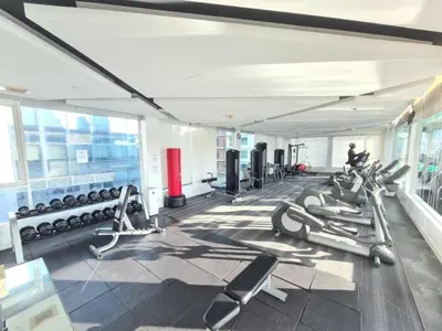 a gym with a lot of treadmills and machines at Comfortable Zone in Khlong Toei