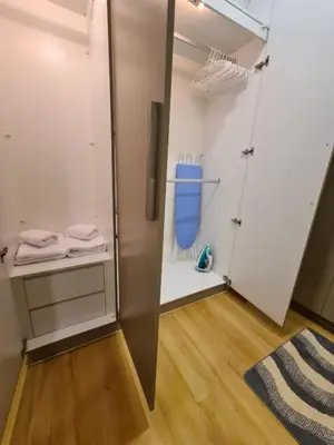 a room with a closet with white walls and wooden floors at Comfortable Zone in Khlong Toei