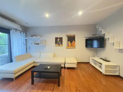 a living room with a white couch and a tv at Bangkok Phomphong Villa\u8054\u6392\u6cf0\u5f0f\u522b\u5885 in Bangkok