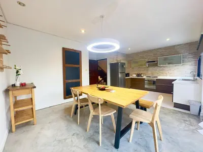 a kitchen with a wooden table and chairs at Bangkok Phomphong Villa\u8054\u6392\u6cf0\u5f0f\u522b\u5885 in Bangkok