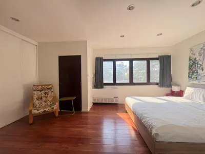 a bedroom with a bed and a chair and a window at Bangkok Phomphong Villa\u8054\u6392\u6cf0\u5f0f\u522b\u5885 in Bangkok