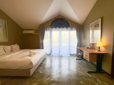 a bedroom with a bed and a desk and a window at Bangkok Phomphong Villa\u8054\u6392\u6cf0\u5f0f\u522b\u5885 in Bangkok