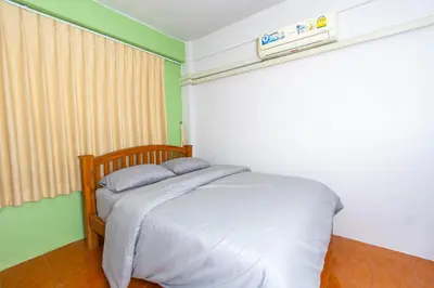 a small bed in a room with a window at TOM CAFE MY House in Thung Maha Mek