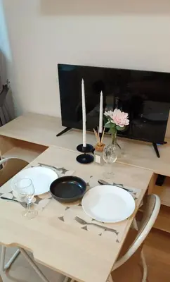 a table with two white plates and two candles at Elio Del Ray Studio walk to BTS in Bangkok
