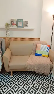 a couch in a living room with a pillow at Elio Del Ray Studio walk to BTS in Bangkok