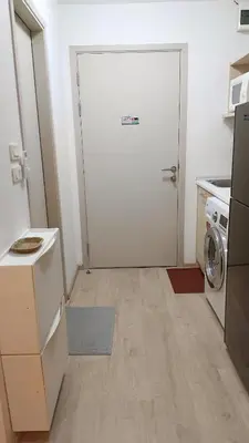 a small kitchen with a white door and a washer at Elio Del Ray Studio walk to BTS in Bangkok