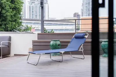 a blue chair sitting on top of a balcony at Luxurious 6BR Villa with Pool & Games at Sukhumvit in Bangkok