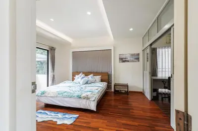 a bedroom with a bed and a wooden floor at Luxurious 6BR Villa with Pool & Games at Sukhumvit in Bangkok
