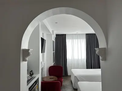 an archway in a hotel room with a bed and a chair at Elizabeth Hotel in Bangkok