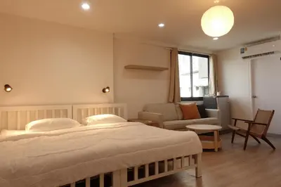 a bedroom with a large bed and a living room at 24 Apt in Bangkok