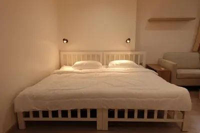 a bed with two pillows and a chair in a room at 24 Apt in Bangkok