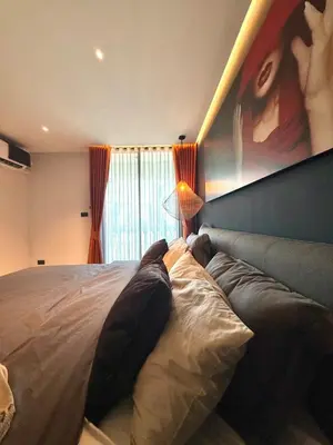 a bedroom with a bed with a painting on the wall at Peaceful Cozy Apt with Stunning View&Full Kitchen in Bangkok