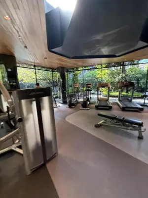 a gym with a row of exercise machines in a room at City Heaven - Coowork - Gym - BTS - Pool - Mall - Starbucks - ShoppingMall in Bangkok