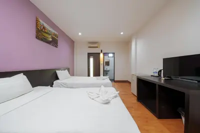 a bedroom with two beds and a desk with a television at Collection O Khaosan Park in Bangkok