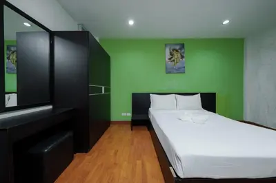 a bedroom with a bed and a green wall at Collection O Khaosan Park in Bangkok