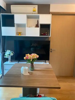 a vase of flowers on a wooden table in a room at CozyroomSukumvit13walktoBTS,MRT in Bangkok