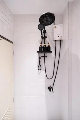 a shower in a bathroom with a hair dryer on the wall at OH Homes - Samsen 10 in Bangkok
