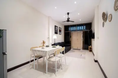 a dining room and living room with a table and chairs at OH Homes - Samsen 10 in Bangkok