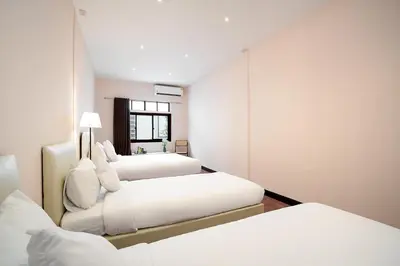 a bedroom with two beds and a mirror at OH Homes - Samsen 12 in Bangkok