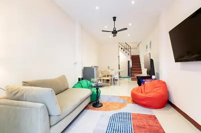 a living room with a couch and a tv at OH Homes - Samsen 12 in Bangkok