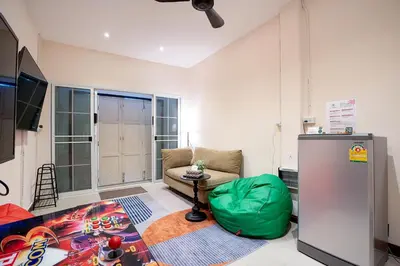 a living room with a couch and a green ottoman at OH Homes - Samsen 12 in Bangkok