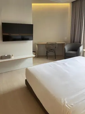 a hotel room with a white bed and a chair at Chinatown Heritage, Chinatown Main road in Samphanthawong