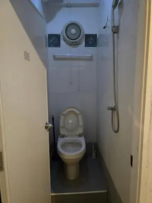 a small bathroom with a toilet and a shower at Jatujak Bangkok guesthouse R5 in Sathani Bang Su
