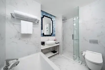 a white bathroom with a toilet and a sink at La Clef Bangkok by The Crest Collection in Bangkok