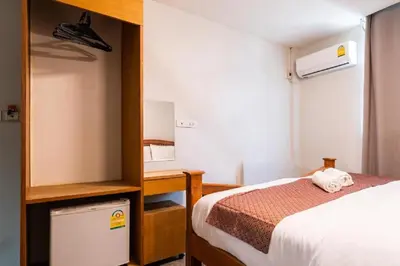 a small room with a bed and a desk and a bed at XX GO INN Khaosan ตรอกข้าวสาร สนามหลวง in Bangkok