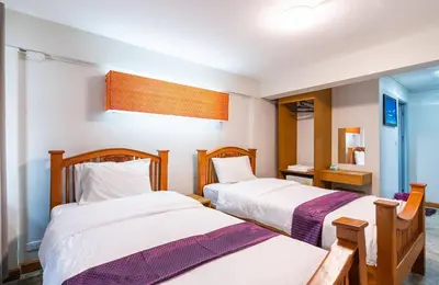 a bedroom with two beds and a mirror at XX GO INN Khaosan ตรอกข้าวสาร สนามหลวง in Bangkok