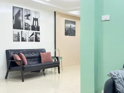 a black leather couch in a room with pictures on the wall at \u65e5\u97e9\u65c5\u6e38\u533a\u5e02\u4e2d\u5fc35\u623f\u522b\u5885\u6c11\u5bbf in Bangkok