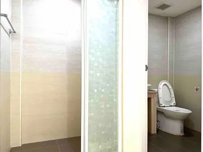 a bathroom with a toilet and a glass shower door at \u65e5\u97e9\u65c5\u6e38\u533a\u5e02\u4e2d\u5fc35\u623f\u522b\u5885\u6c11\u5bbf in Bangkok