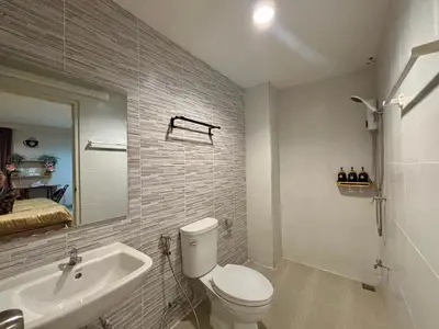a bathroom with a toilet and a sink and a mirror at โรงพักบางระมาด by ModiCoff Café in Sathani Ban Chim Phali