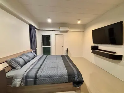 a bedroom with a bed and a flat screen tv at โรงพักบางระมาด by ModiCoff Café in Sathani Ban Chim Phali